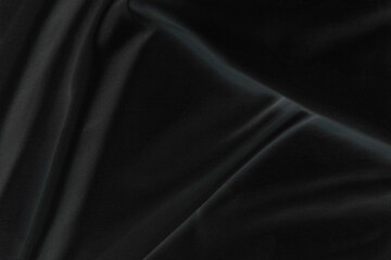 Smooth elegant black silk fabric or satin luxury cloth texture for abstract background