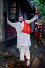 Obraz na płótnie Canvas South asian hindu religious young aged boy cosplays as a foreteller in gajan festival 