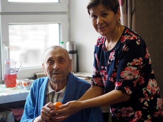 Native people are caring for a 92-year-old grandfather, who is sitting in his room. Elderly care, personal hygiene and mental health.
