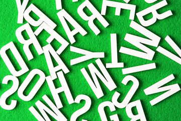 Alphabet background. Random order letters. Typography texture. Wooden letters on green fabric. Eco letters background.