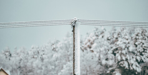 Local electric pole covered with ice and snow. Concept of electricty and blackouts problem during...