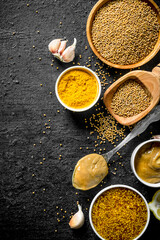 Different types of mustard with garlic cloves.