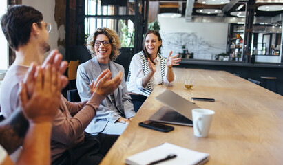 Happy business people applauding during a meeting in an office