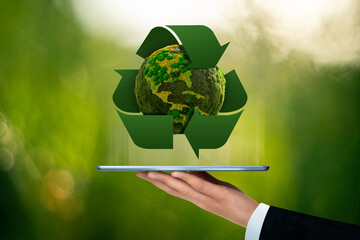 Businessman is holding a digital tablet with green planet Earth with recycling symbol. Concept