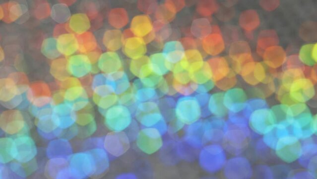 虹色に光り回転するラメとクリスタルのキラキラのボケの背景