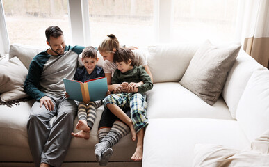 Happy, learning and parents reading a book with children for bonding, fun and quality time. Knowledge, information and boys excited about a story on the lounge sofa with their mother and father - Powered by Adobe