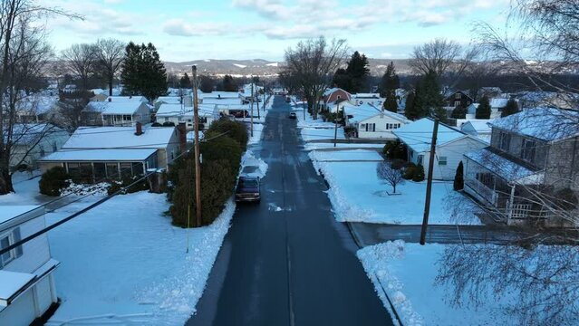 Aerial dolly forward in snow covered neighborhood outside of Williamsport PA. Small snowy houses.