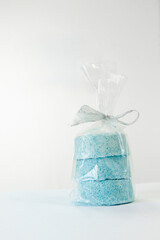 Salt bath bombs in a gift wrap on light background. For skin care and aromatherapy in beauty salons.