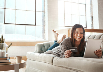 Online shopping, ecommerce and credit card with digital tablet by woman on a sofa, happy and relax. Online banking, debit card and girl checking credit score, savings or membership in a living room