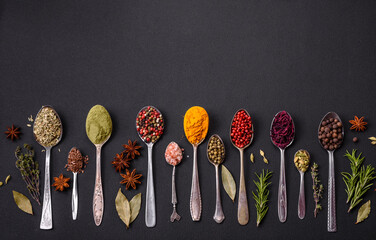 Composition consisting of variations of spices in white bowls and metal spoons