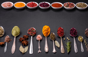 Composition consisting of variations of spices in white bowls and metal spoons