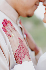 Woman Hands with red henna tattoo. Hands of Malay bride girl with red henna tattoos.