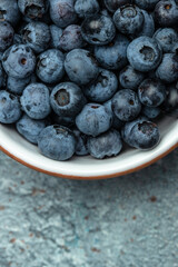 fresh organic blueberries in bowl background, vertical image. top view. place for text