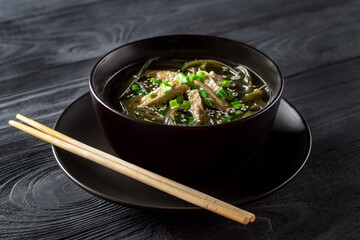 Korean seaweed soup with meat in a black bowl. Birthday soup. Korean cuisine. Healthy diet. Pregnancy. Tradition. Custom.