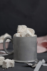 There is a cup on the table filled with handmade sweets