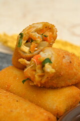 some chicken meat risol cakes on a wooden plate with vegetables (in indonesia called Risol Ayam)