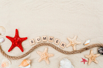 The concept of a holiday at the sea. Shells, a straw hat, lime flip-flops and the inscription "summer" on the sand. Background for summer holidays with space for text. Top view.