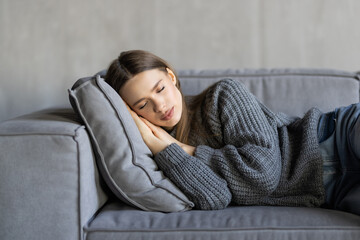 Obraz premium Young attractive woman sleeping on the couch in the living room