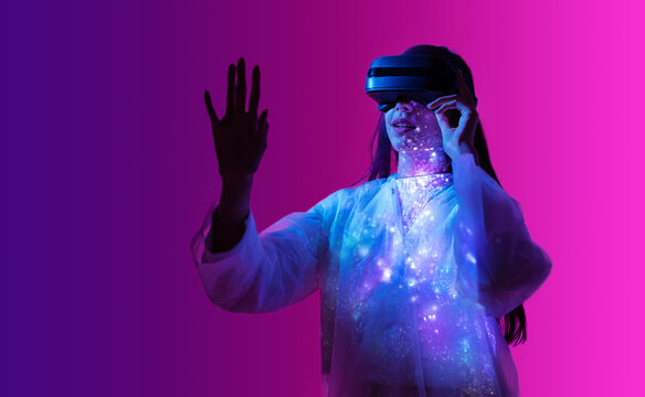 Young woman touching helmet and wearing virtual reality headset. Future digital vr technology and entertainment. Space exploration with augmented reality glasses