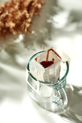 The process of making coffee drip in a transparent glass. Sunny morning breakfast. The coffee filter is poured with hot water