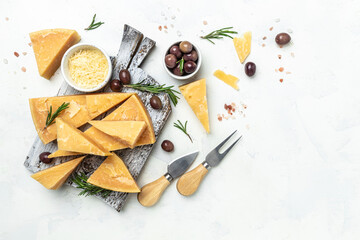 Parmesan cheese, Hard cheese, rosemary and cheese knife on a gray background. Long banner format. top view