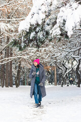 Winter portrait of an attractive young woman in a snowy park, outdoors