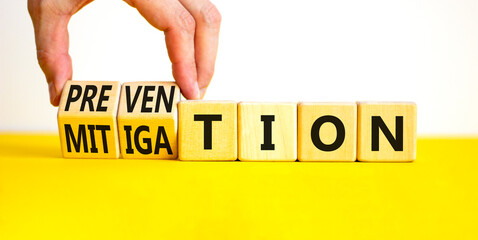 Prevention or mitigation symbol. Businessman turns cubes and changes the concept word Mitigation to Prevention. Beautiful white background. Business prevention or mitigation concept. Copy space.