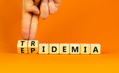 Covid-19 epidemic or tridemic symbol. Concept word Epidemic and Tridemic on wooden cubes. Doctor hand. Beautiful orange background. Medical Covid-19 epidemic or tridemic concept. Copy space