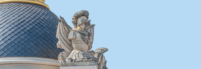 Old statue of Renaissance Era Roman man knight in armor, Potsdam, Germany, at solid blue sky...