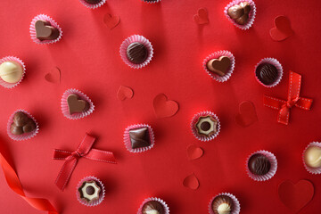 Chocolates on paper mold on a decorated red table