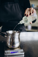 Pouring melted wax. Handmade soy candles with mica and wooden wick. Amber and opaque container. Vegan product without animal cruelty.