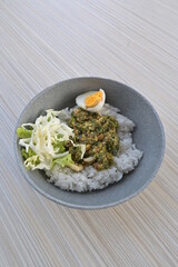 green chili squid rice with salad on wooden table (natural light)