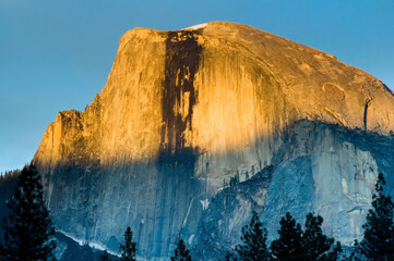 Half Dome basks in golden light at sunset in Yosemite National Park, CA.