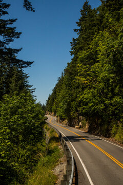 The famous Chuckanut Drive near Bellingham, Washington attracts bikers and drivers who enjoy the original scenic drive in Washington as it hugs the coastline and winds through thic