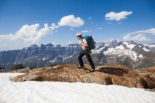 A woman hikes near the summit of Tierbergli, Bern, Switzerland with climbing equipment.