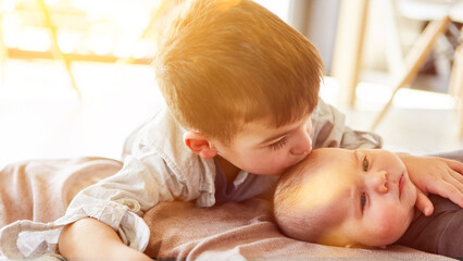 Großer Bruder gibt Baby Kuss auf die Stirn zu Hause