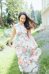 Naklejka premium Happy multiracial Japanese woman in romantic floral maxi dress in