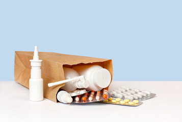 a paper bag with medicines lies on a table on a blue background. Delivery concept