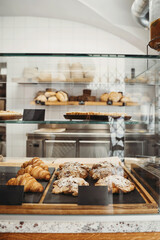 Interior details at the bakery and coffee shop. Bistro showcase with shelves of freshly croissants...