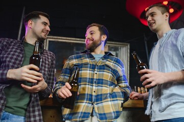 Friends resting in the pub with beer in hands. Having conversation.