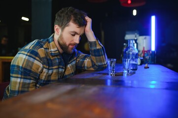 Sad man sitting at bar counter, alcohol addiction