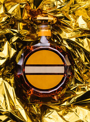 bottle of cognac on golden foil background