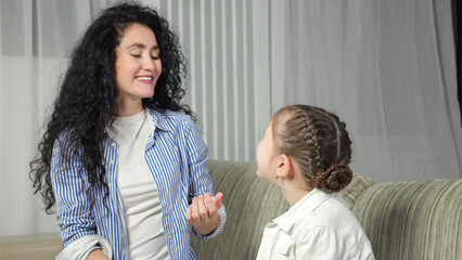 Female speech therapist helps girl kid to make correct sound and teaches child to words right. Junior schoolgirl learns to pronounce sounds at home