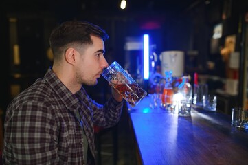 Tasting a good beer. Portrait of thoughtful men drinking beer at the bar