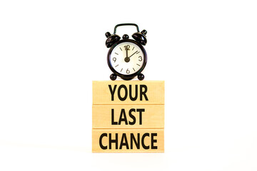 Time to your last chance symbol. Concept words Your last chance on wooden blocks on a beautiful white table white background. Black alarm clock. Business and your last chance concept. Copy space.