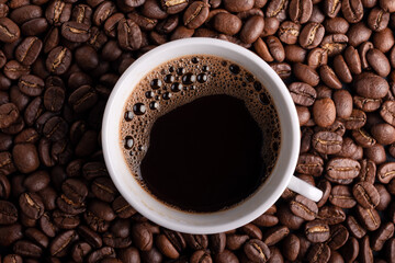 Morning black coffee or espresso in white cup with roasted coffee beans