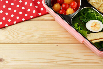Lunch boxes with ready food on wooden background