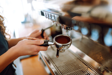 Female barista making coffee in coffee shop counter. Takeaway food.