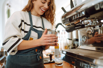 Female barista making coffee in coffee shop counter. Takeaway food.