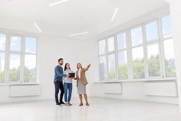 Real estate agent showing new apartment to couple